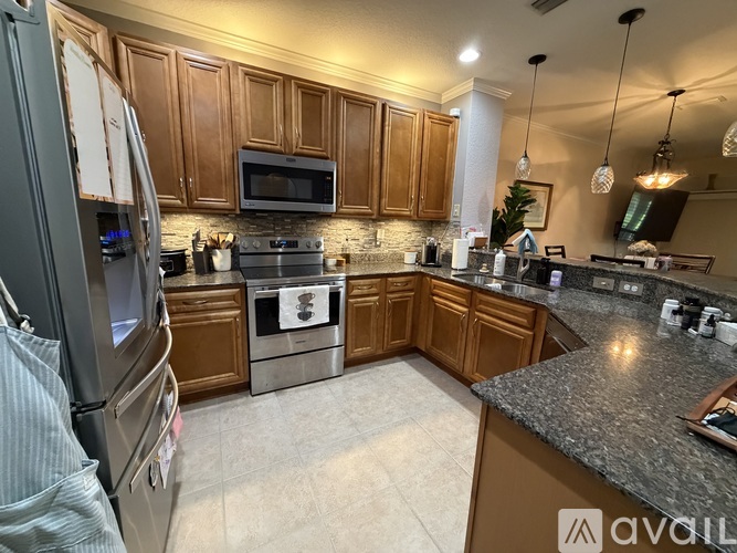 A kitchen with granite countertops and wooden cabinets.