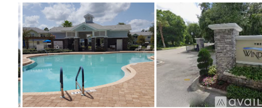 A swimming pool with a building in the background and a sign that says "The Wind".