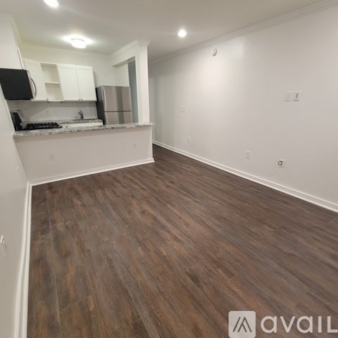 A kitchen with white cabinets and a wooden floor.