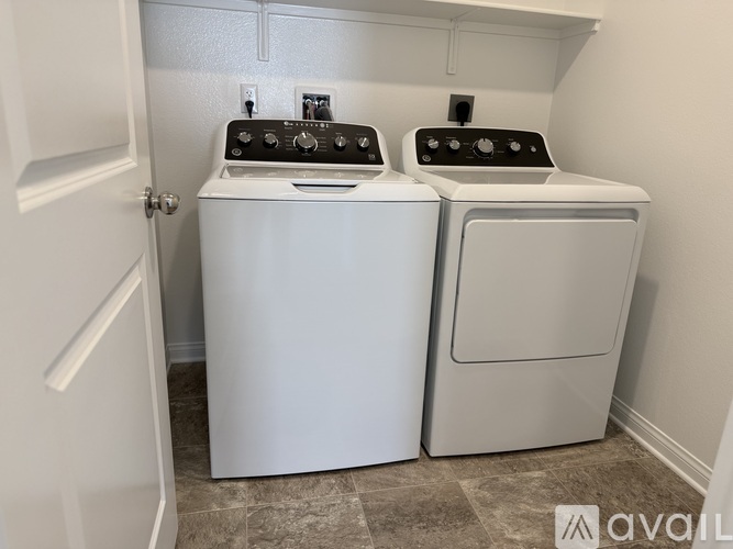 Two white front loading washing machines in a laundry room.