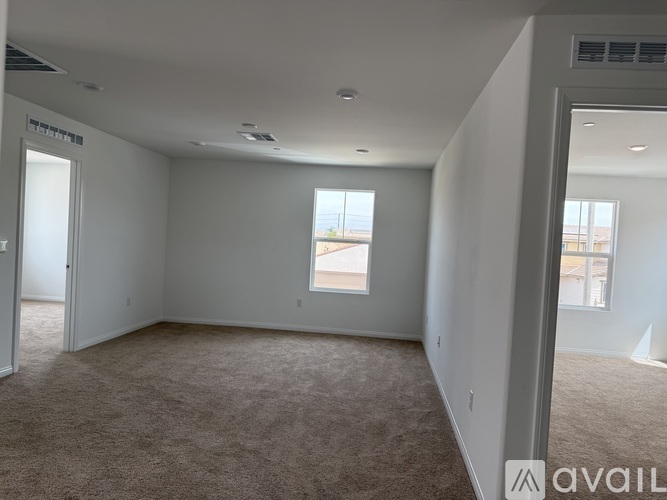 A spacious room with carpeted floor and a window.