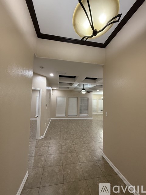 A hallway with a tiled floor and a light fixture on the ceiling.