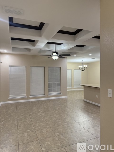 A room with a ceiling fan and tiled flooring.