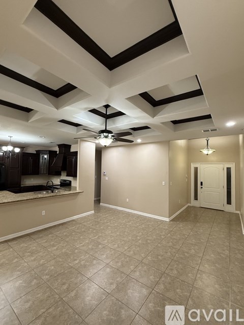 A spacious room with a fan and a large mirror on the wall.