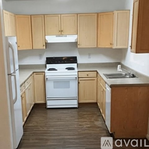 A kitchen with wooden cabinets and white appliances.