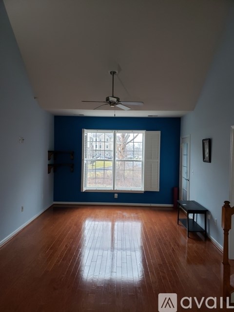 A room with a ceiling fan and a window.
