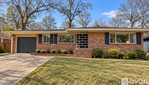 A house with a grey garage door and a brick wall.