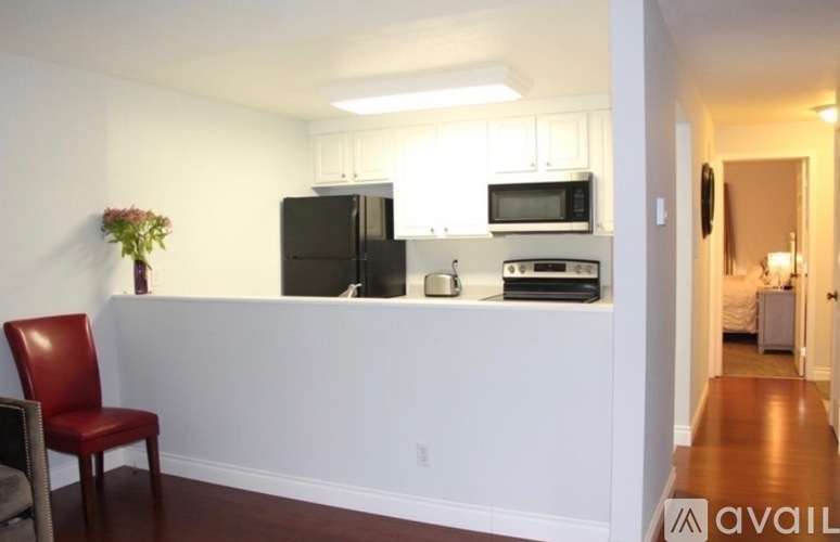 A kitchen with a black refrigerator, microwave, and stove top oven.