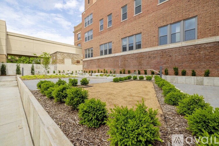 A building with a brick wall and a landscaped area in front.