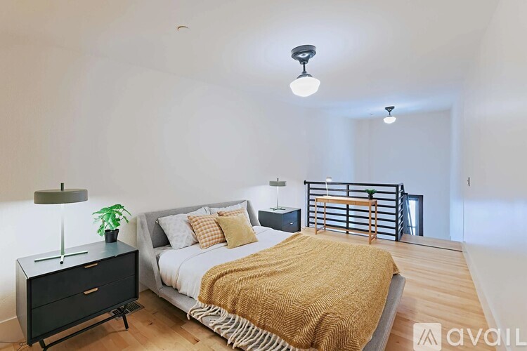 A bedroom with a bed, nightstand, and lamp.