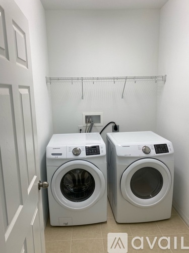 Two front loading washing machines in a small laundry room.