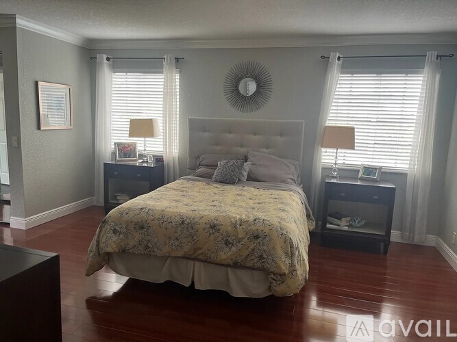 A bedroom with a large bed and two nightstands with lamps.