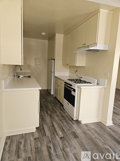 A kitchen with a stove top oven and a refrigerator.