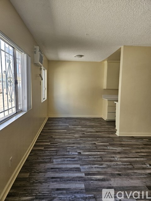 A long hallway with a carpeted floor and a window on the left side.