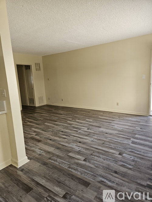 A room with wooden flooring and a wall-mounted elevator.