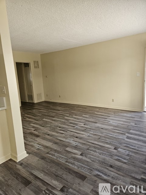 A room with wooden flooring and a wall-mounted elevator.