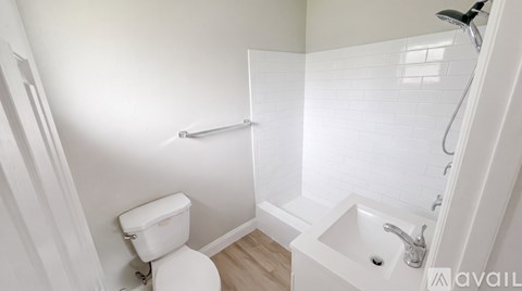 A white toilet is next to a white sink in a small bathroom.
