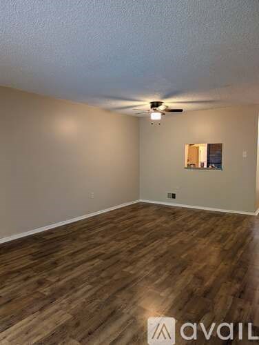 A room with wooden flooring and a ceiling fan.