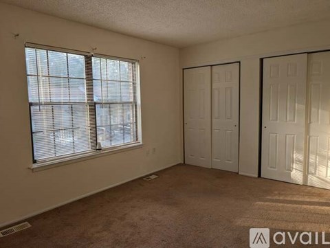A room with a window and two doors is available for rent.
