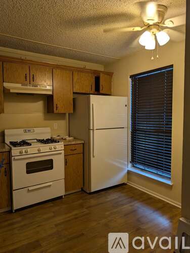 A kitchen with white appliances and wooden cabinets.