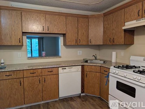 A kitchen with wooden cabinets and a white stove.