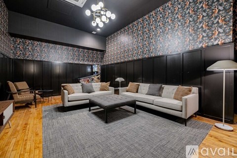 A living room with a grey rug and a white sofa.