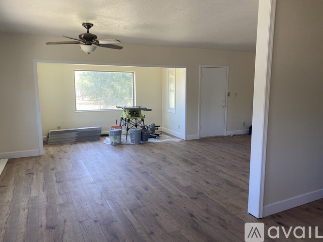 A room with a ceiling fan and wooden flooring.