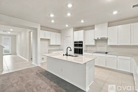 A modern kitchen with white cabinets and a central island.
