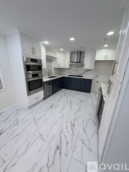 A kitchen with marble flooring and white walls.