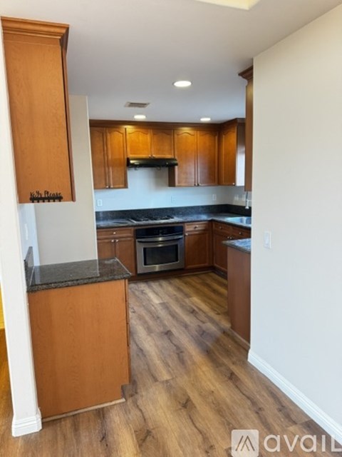 A kitchen with wooden cabinets and a granite countertop.