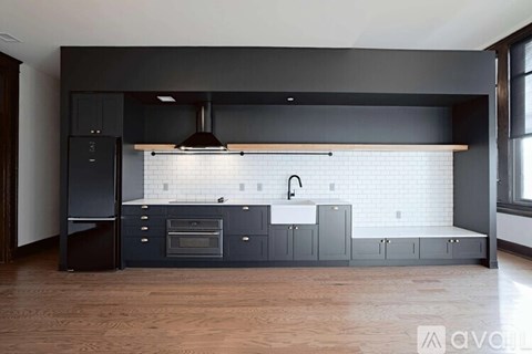 A modern kitchen with dark wood floors and a white subway tile backsplash.