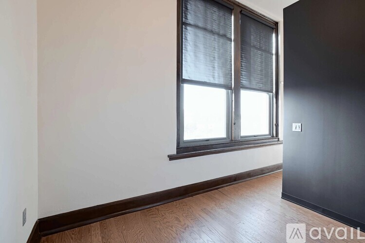 A room with a window and wooden flooring.