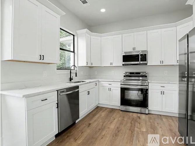 A kitchen with white cabinets and stainless steel appliances.