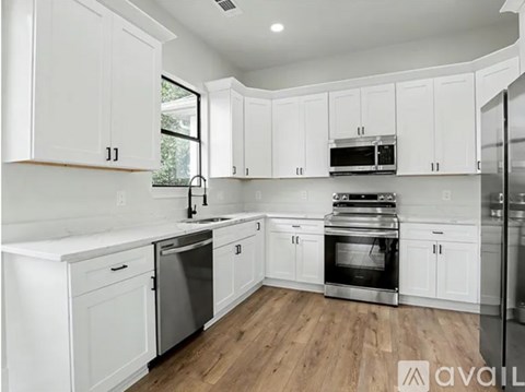 A kitchen with white cabinets and stainless steel appliances.
