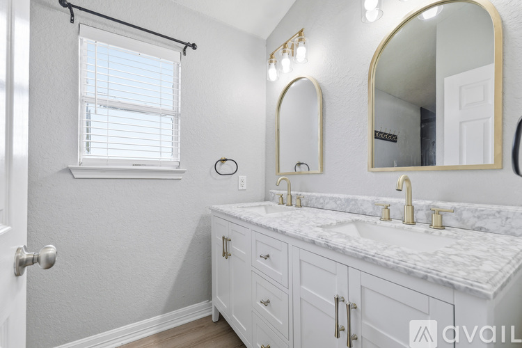 A bathroom with a marble countertop and a large mirror.