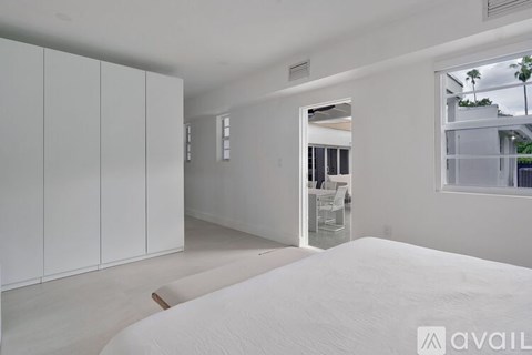 A bedroom with a large bed and a view of a balcony.