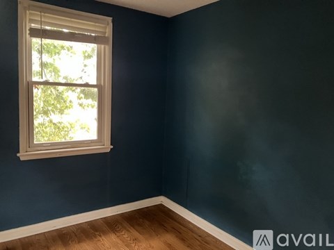A room with a window and dark blue walls.