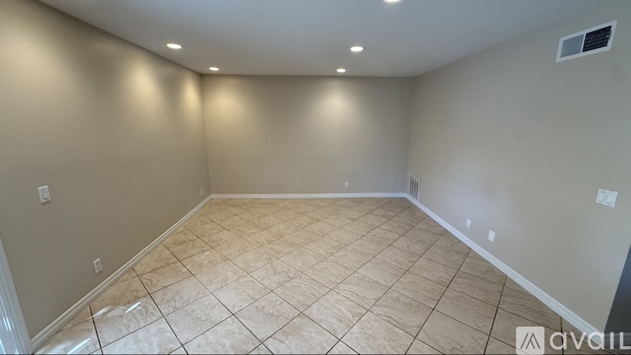 A room with beige tiled flooring and white walls.