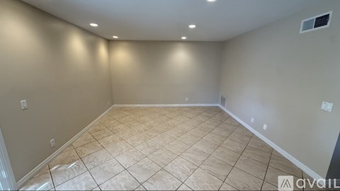 A room with beige tiled flooring and white walls.