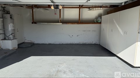 A large empty room with a concrete floor and white walls.