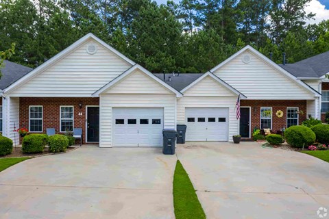 A two-story house with a garage and a driveway.