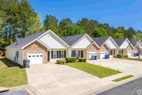 A row of houses with a driveway in front.