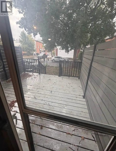 A rainy day view from a window looking out to a wet street.