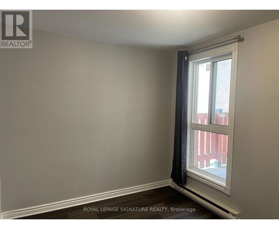 A room with a window and a view of a red building outside.