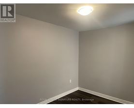 A room with a light on the ceiling and a wall socket on the wall.