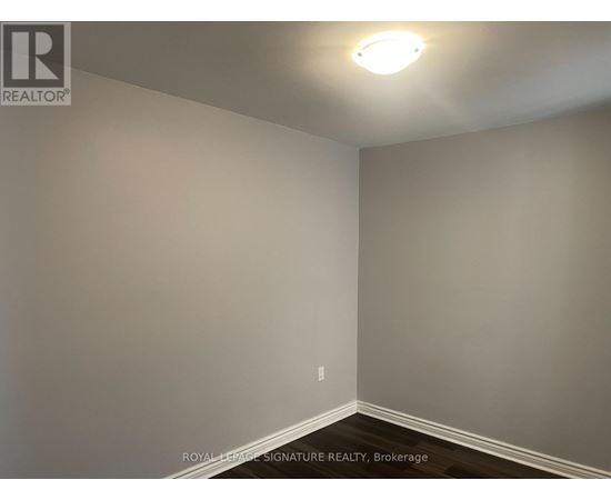 A room with a light on the ceiling and a wall socket on the wall.