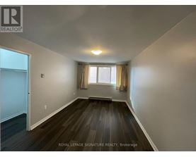 A room with wooden floors and a window with curtains.