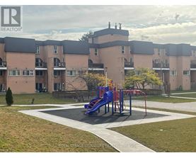 A playground with a blue slide in front of apartment buildings.