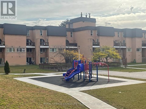 A playground with a blue slide in front of apartment buildings.
