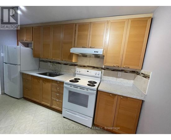 A kitchen with wooden cabinets and a white stove top oven.